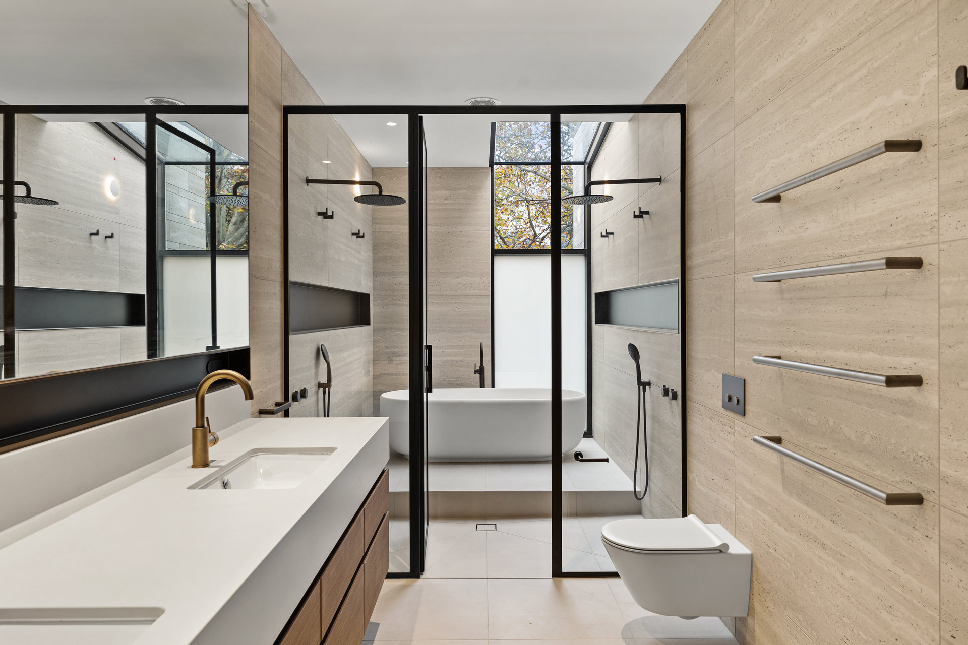 Travertine ensuite with black-framed shower